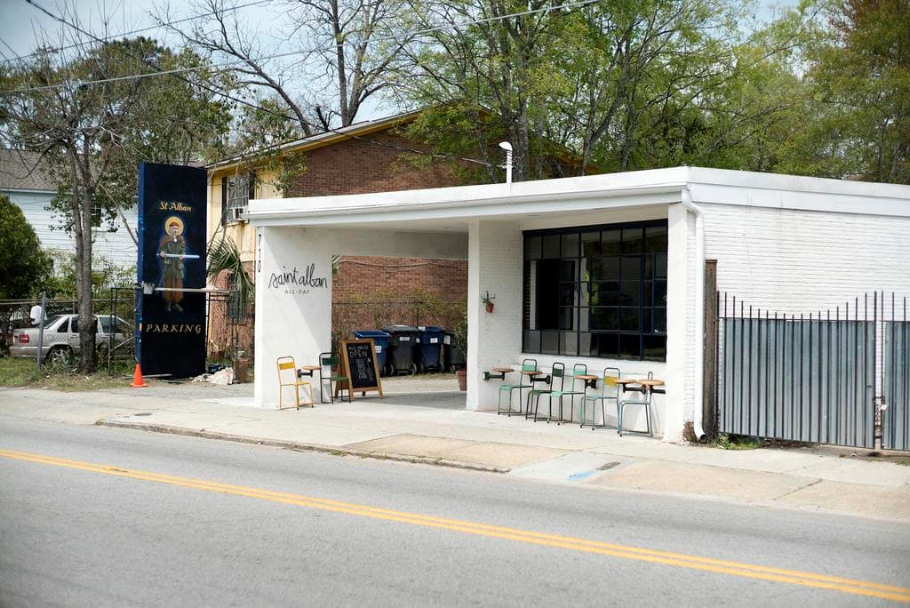 Ein Restaurant, das neben einer Straße mit Bäumen im Hintergrund liegt.