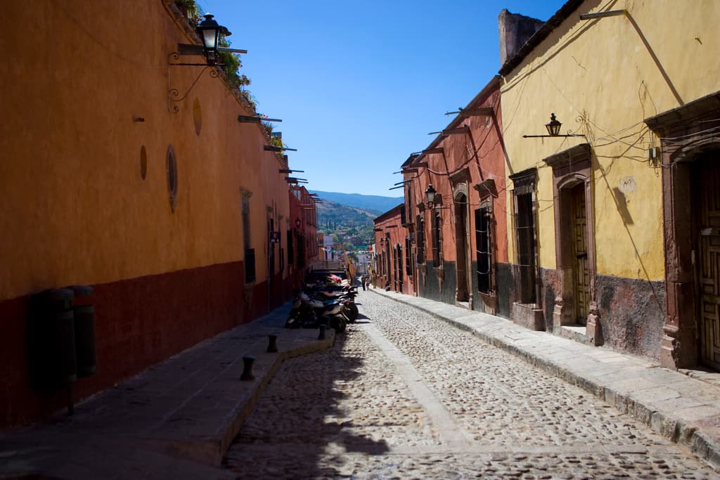 Eine leere Straße mit zahlreichen parkenden Fahrrädern, umgeben von mehreren Gebäuden, mit einem Gebäude prominent im Vordergrund.