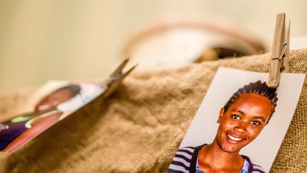 Auf einem Tisch liegt eine Klammer, ein Passfoto und ein Stoffstück auf der rechten Seite, mit einem unscharfen Hintergrund und linker Seite.