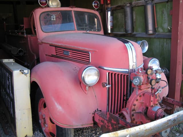 Ein Kraftfahrzeug steht auf einem mit Steinen bedeckten Boden mit Feuerlöschern an der benachbarten Wand.
