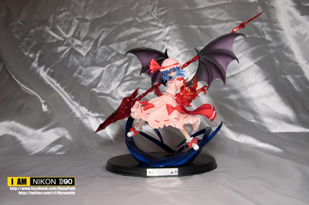 Ein Spielzeug liegt auf einem silbernfarbenen Tuch mit sichtbaren Wasserzeichen auf dem Bild.