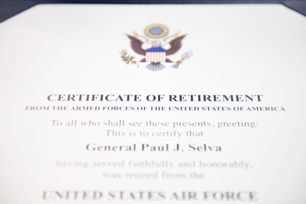 Rahmenurkunde für den Ruhestand der United States Air Force mit blauem Rand, zentralem Stern in einem Lorbeerkranz und einem "Ruhestand"-Banner auf einem Schild-Logo, alles in schwarzer Schrift.