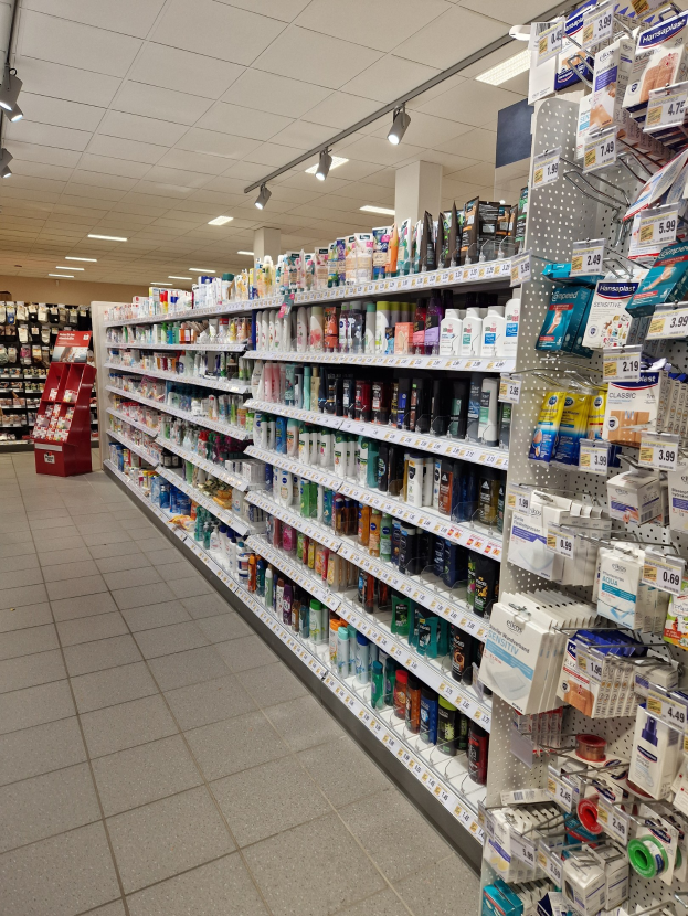 Eine Apothekenregal mit verschiedenen Medikamenten in Regalen mit Deckenbeleuchtung.