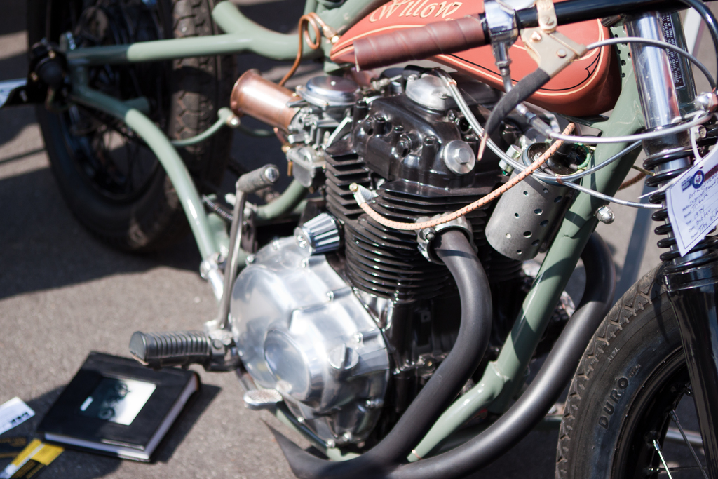 Mehrere Motorräder in einer Reihe geparkt mit einem Buch auf dem Sitz eines davon.