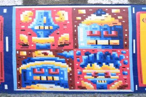 Ein buntes Wandgemälde an einem Gebäude in Berlin, Deutschland, mit verschiedenen Formen und leuchtenden Farben.