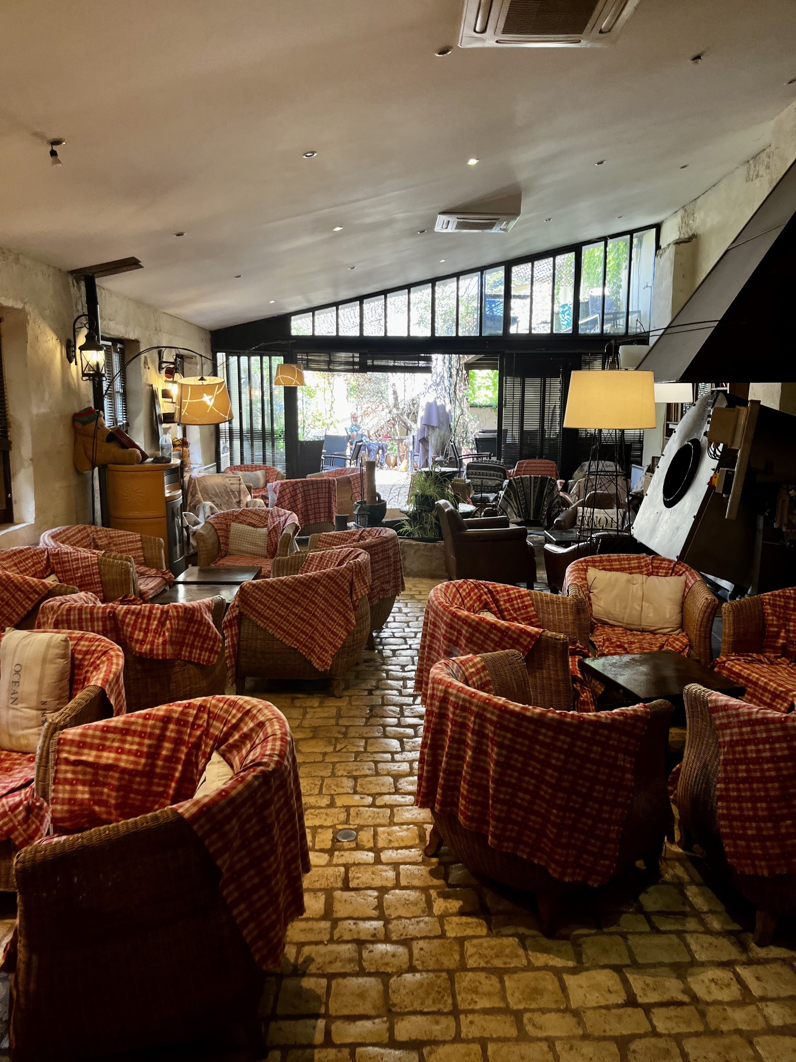 Empfang des Rathauses mit Stuhlreihen, Tischen, gepolsterten Sofas, Wandlampen, Deckenluft conditioning und Glasfenstern im Hintergrund.