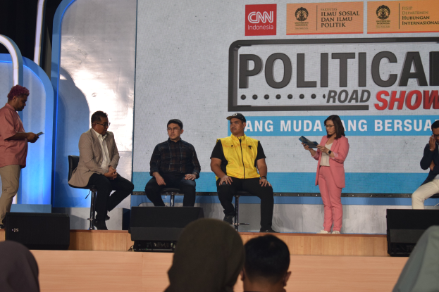 Eine Gruppe von Menschen auf einer Bühne mit einigen Stehenden an einem Podium und einem Schild im Hintergrund mit der Aufschrift "Cnn Political Road Show".