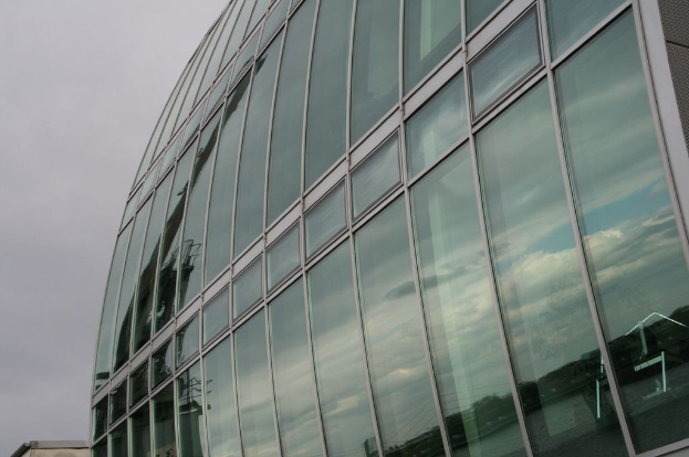 Ein großes Glas-Gebäude unter einem blauen Himmel.