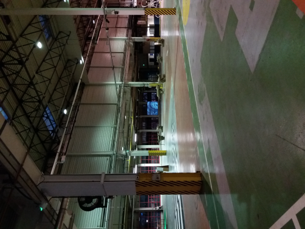 Ein großes Lager voller verschiedener Maschinen, Metallstangen, Lampen und andere Gegenstände, mit Text auf dem Boden auf der rechten Seite.