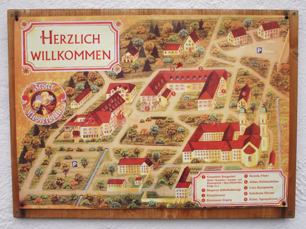 Ein detaillierter Stadtplan von Herzlich Willkommen, Deutschland, der an einer Gebäudewand angebracht ist und Straßen, Gebäude, Sehenswürdigkeiten und zusätzliche Informationen zur Geschichte, Kultur und Attraktionen der Stadt zeigt.