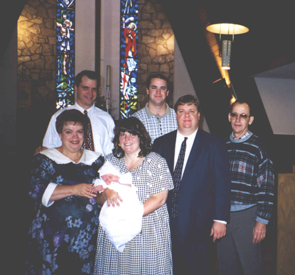 Eine Frau, die ein Baby hält, mit einem hellen Licht im Hintergrund.