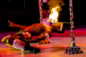 Eine Person schaut auf ein Feuer, das auf einem Stab brennt, der an Pfosten befestigt ist.