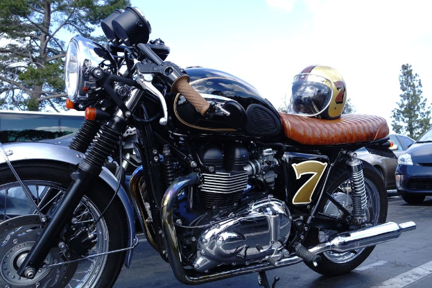 Ein Fahrrad mit Helm befindet sich in der Mitte des Bildes, umgeben von Autos, Bäumen, Himmel und einer Straße am Boden.