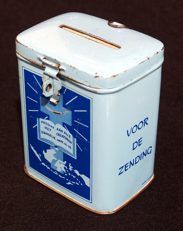 Weißer und blauer Blechspartopf mit einem blauen und weißen "Voor de Zending"-Schild, auf einer schwarzen Oberfläche.