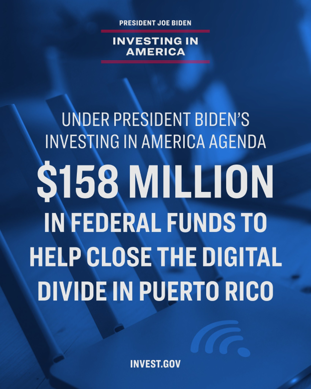 Plakat mit der Aufschrift "Unter Präsident Bidens Investing in America-Agenda: 158 Millionen Dollar Bundesmittel, um die digitale Kluft in Puerto Rico zu schließen" mit einem Laptop, Papieren und einem Kaffeebecher auf einem Tisch davor.