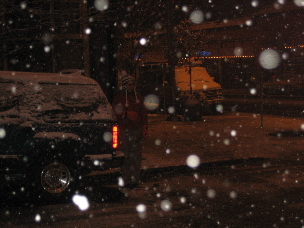 Eine dunkle Szenerie mit Schneefall und zwei Fahrzeugen auf einer Stra├če.