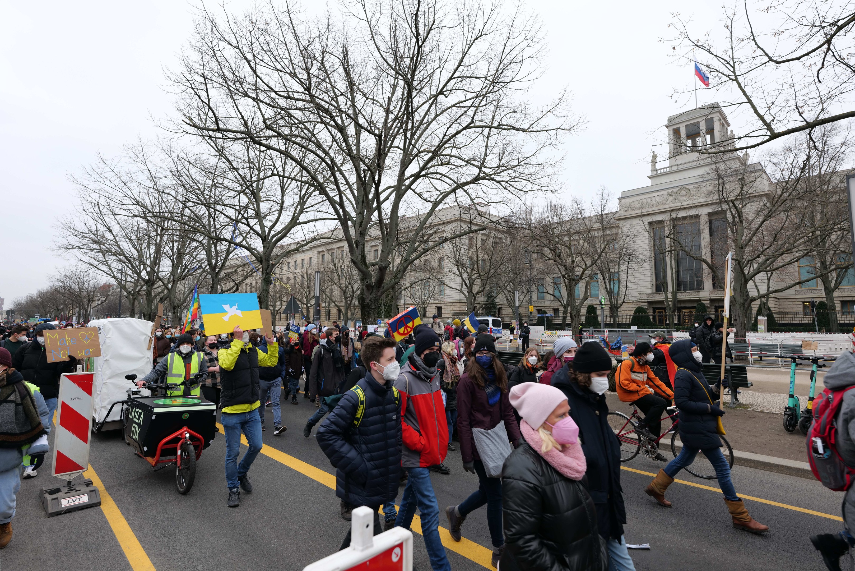 Eine große Gruppe von Menschen marschiert bei einer Demonstration in Washington, D.C. am 21. Januar 2020, einige halten Schilder und andere fahren Fahrräder, mit Bäumen und einem klaren blauen Himmel im Hintergrund.