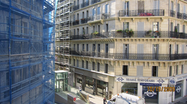 Ein großes Gebäude unter construction auf der linken Seite, mit einem Geschäft auf der rechten Seite unten.