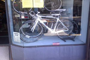 Mehrere Fahrräder sind in einer Glasvitrine ausgestellt.
