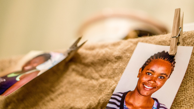 Auf einem Tisch liegt eine Klammer, ein Passfoto und ein Stoffstück auf der rechten Seite, mit einem unscharfen Hintergrund und linker Seite.