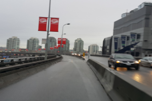 Eine fast leere Straße mit Gebäuden im Hintergrund und ein paar Pfosten in der linken Ecke.