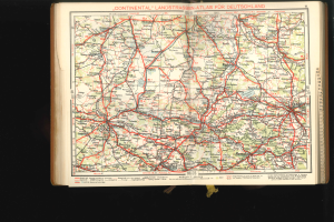 Ein aufgeschlagenes Buch mit einer detaillierten Deutschlandkarte, die Straßen und Autobahnen zeigt, vor schwarzem Hintergrund.