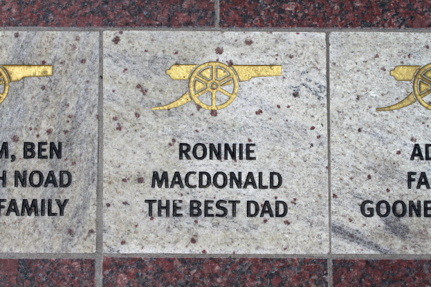 Eine historische Gedenktafel mit Symbolen und Text in der Mitte des Bildes.