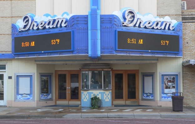 Außenansicht des Dream Theaters in St. Louis, Missouri, mit Glastüren, Fenstern, einem Namensschild, einem Müllcontainer, einem Topf mit einer Pflanze und einer Straße unten.