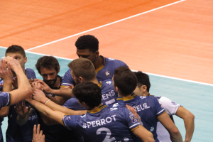 Eine Gruppe von Männern in blauen "Ligue 1"-T-Shirts feiert auf einem Volleyballfeld.