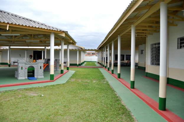 Unterstände mit Säulen und Räumen, umgeben von einer Grasfläche.