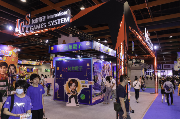 Gruppe von Teilnehmern, die durch einen Convention-Hall auf einer Gaming-Messe in China gehen, einige tragen Taschen und halten Gegenstände, mit Anzeigetafeln, Deckenbeleuchtung und Teppichboden.