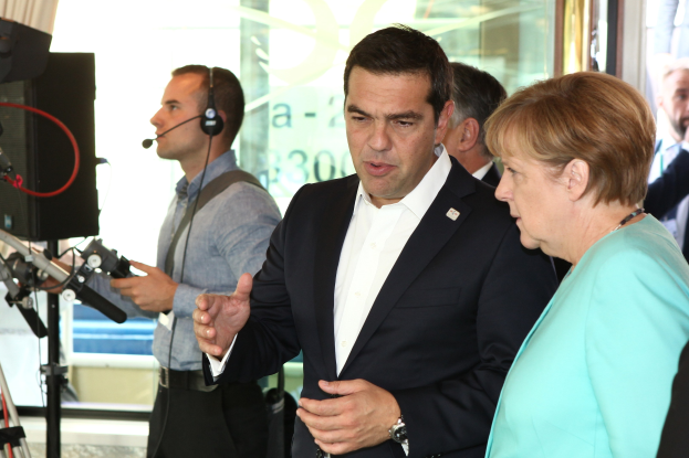 Bundeskanzlerin Angela Merkel und Joachim Gauck sprechen an einem Podium mit Mikrofonen, vor einer Glaswand und einem Vorhang.