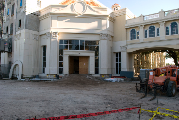 Ein Gebäude mit Glasfenstern, ein Fahrzeug und ein Baum davor.