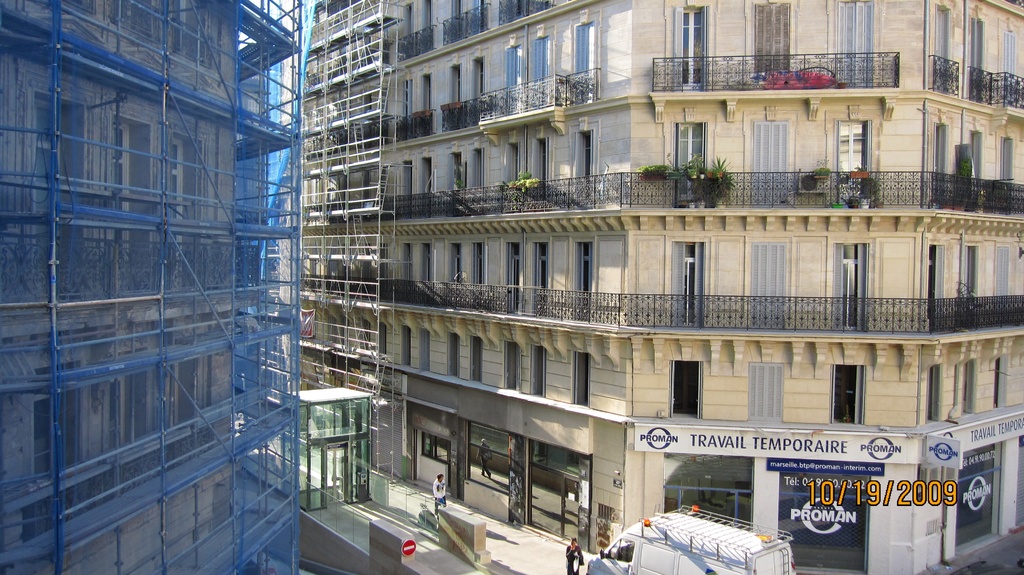 Ein großes Gebäude in Bau auf der linken Seite, mit einem Geschäft auf der rechten Seite unten