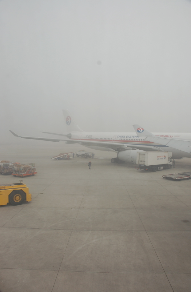 Ein Flugzeug und Fahrzeuge befinden sich auf einer Landebahn.