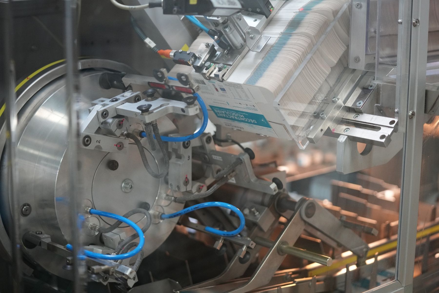 Automatisierte Verpackungssystemmaschine auf einem Fabriktisch mit unscharfen Hintergrundobjekten.