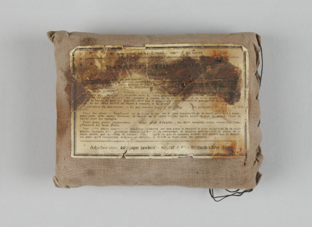 Kleiner Verbandskasten mit einem informativen Blatt Papier oben drauf.