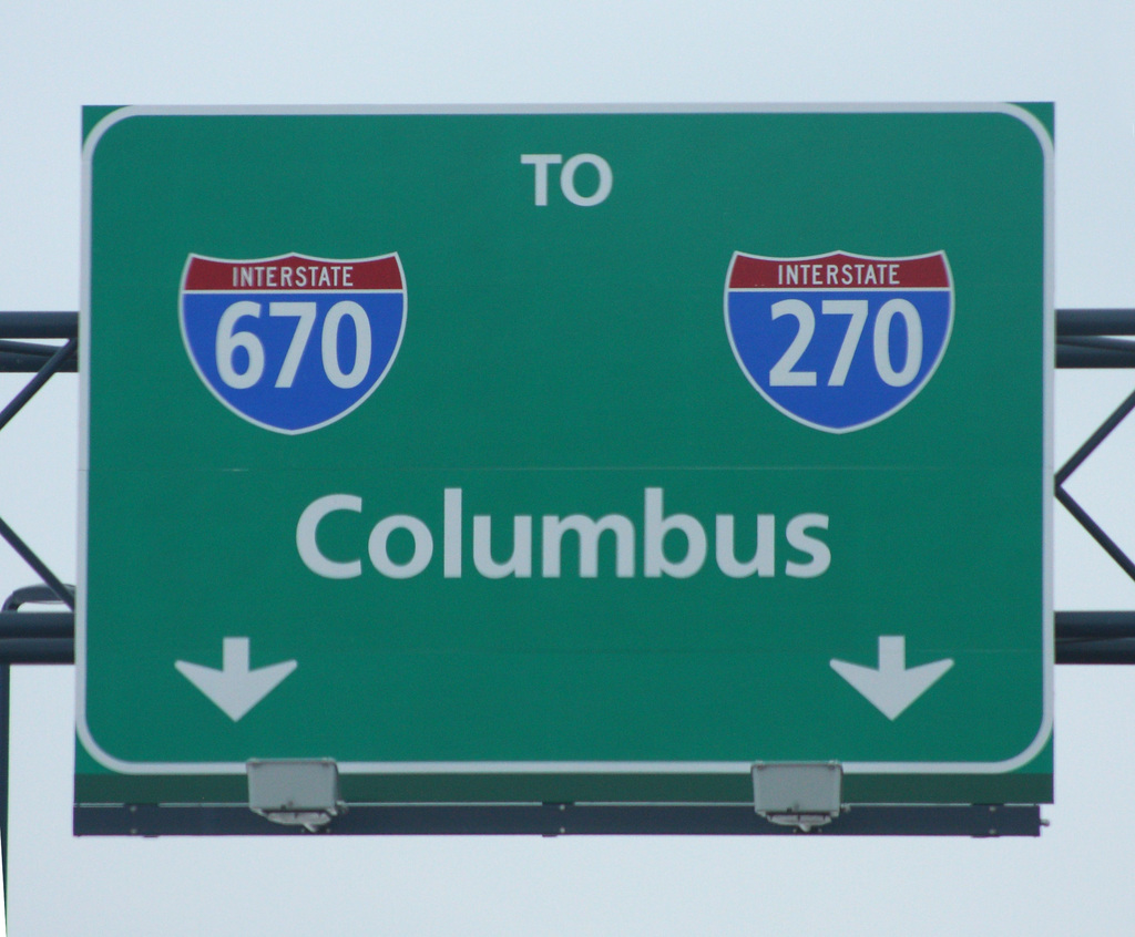 Ein grünes Schild mit Zahlen und Text auf einem Werbetafel