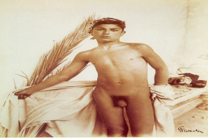 Ein junger Junge steht nackt auf einem Bett, hält ein Tuch und hat verschiedene Gegenstände rechts vom Bett und Text unten im Bild.